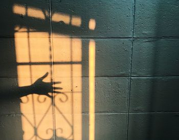 Shadow of hand on tiled wall