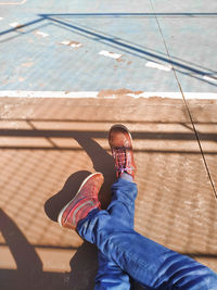High angle view of a seated person's leg, wearing shoes
