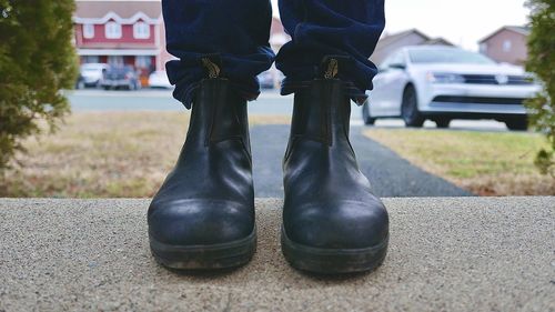 Low section of man standing on road