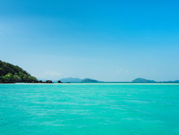 Scenic view of white sand bar and turquoise sea against blue sky. koh kham island, trat, thailand.