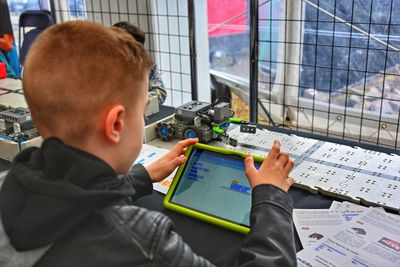 High angle view of boy programming a robot