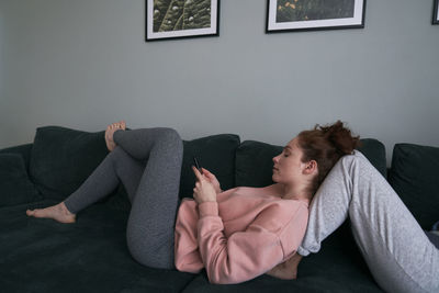 Young woman sitting on sofa at home