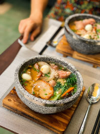 Cropped hand of person preparing food on table