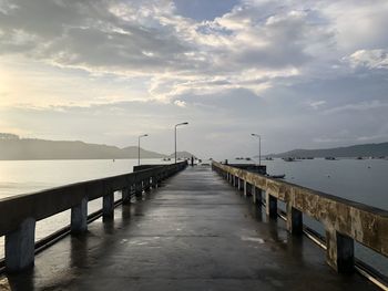 Pier over sea against sky during sunset