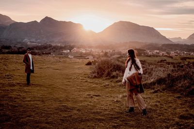 Rear view of women walking on landscape