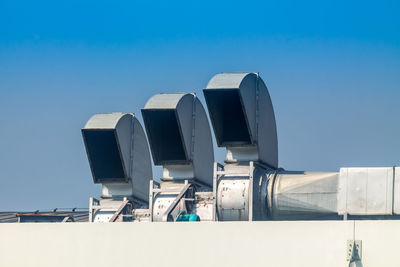 Low angle view of factory against clear blue sky