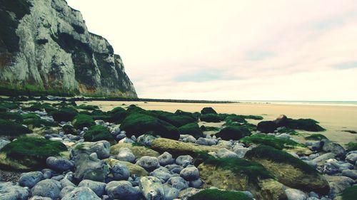 Rocks by sea against sky