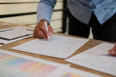 Midsection of design professional working on table