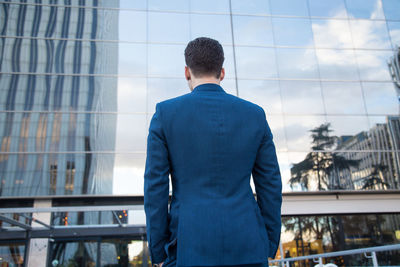 Rear view of businessman standing against modern building