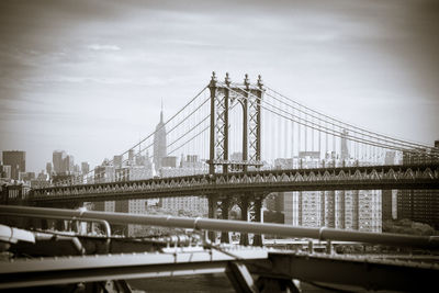 Manhattan bridge in city against sky