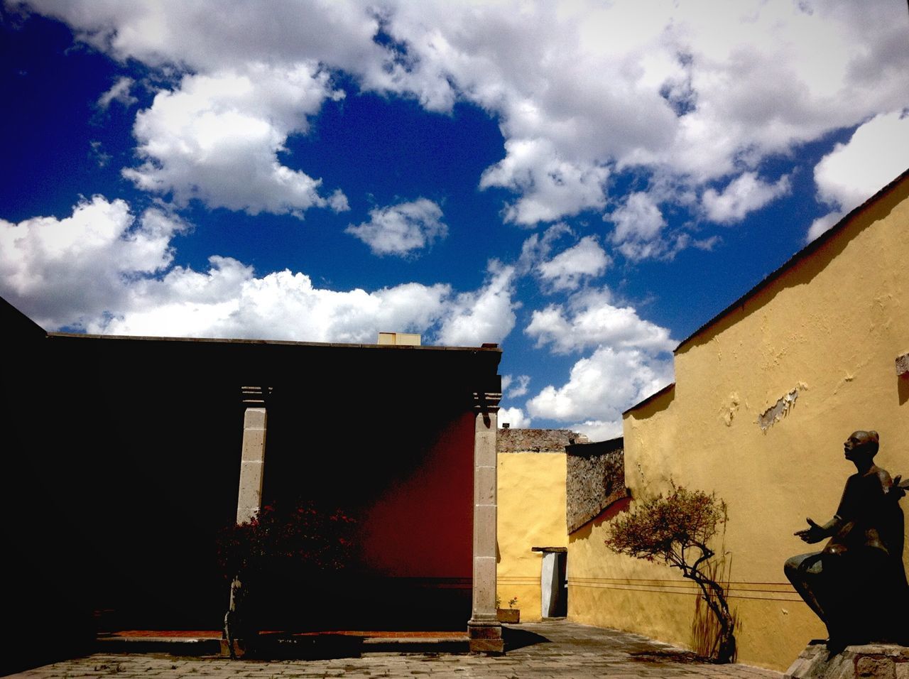 architecture, built structure, building exterior, sky, cloud - sky, house, street, the way forward, cloud, residential structure, residential building, wall - building feature, building, outdoors, day, sunlight, wall, men