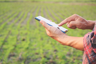 Midsection of man using mobile phone