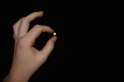 Optical illusion of hand holding moon against sky