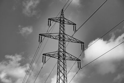 Low angle view of silhouette electricity pylon against sky