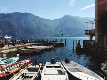 Boats moored at harbor against sky