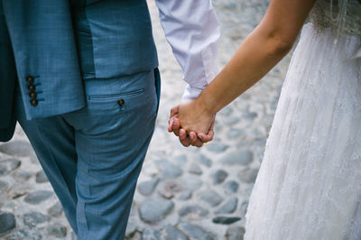 Midsection of couple holding hands