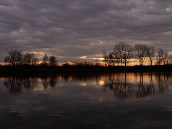 Scenic view of lake against sky at sunset