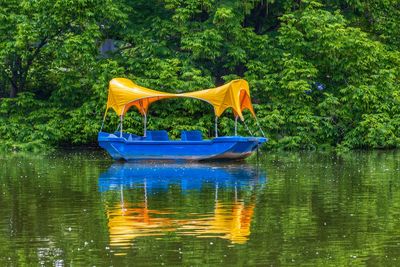 Boats in lake against trees