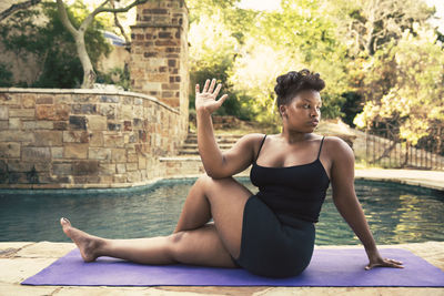 Side view of young woman sitting in swimming pool