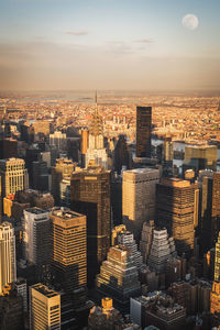 High angle view of modern buildings in city against sky during sunset