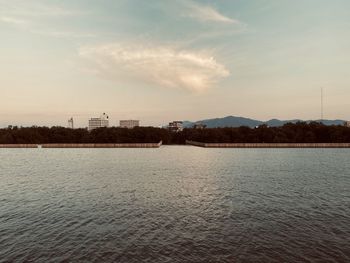 Scenic view of river against sky at sunset