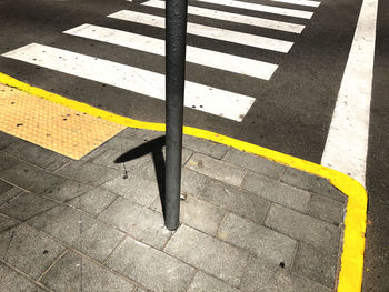 High angle view of yellow crossing sign on road