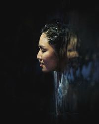 Side view of woman through waterfall