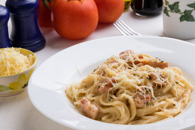 High angle view of spaghetti with carbonara in plate on table