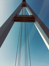 Low angle view of suspension bridge against clear blue sky