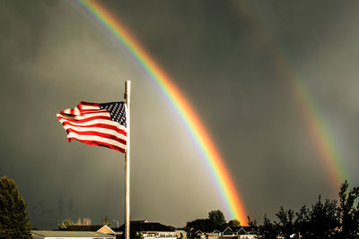 Low angle view of rainbow flag against sky