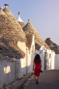 Full length rear view of woman walking against building