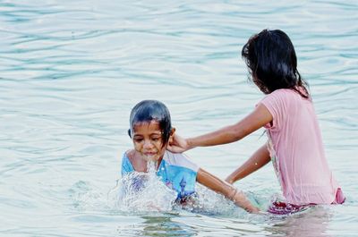 Siblings enjoying in lake