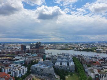 High angle view of city buildings against cloudy sky