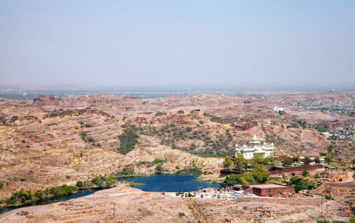 Jaswant thada by lake against clear sky on sunny day