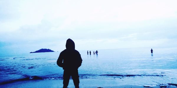 Rear view of man standing on beach