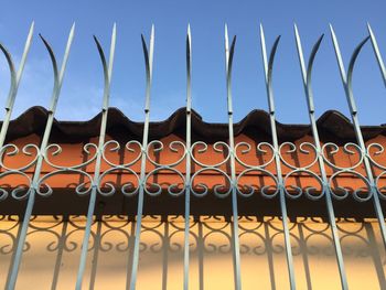 Close-up of metal fence against blue sky