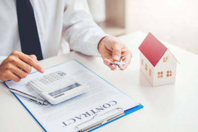 Midsection of woman holding text on white table