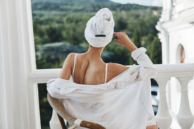 Low section of woman standing against white window