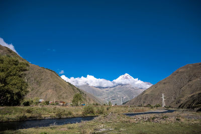 Scenic view of mountains against blue sky