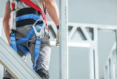 Low section of man standing on railing