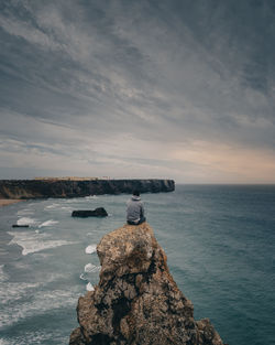 Rear view of man looking at sea against sky