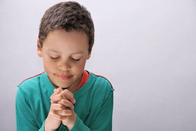 Boy looking away against white background