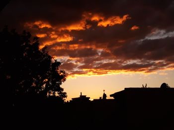 Silhouette trees against orange sky