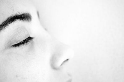 Close-up of teenage girl with eyes closed against white background