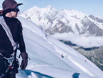 Hiker on snowcapped mountain against sky