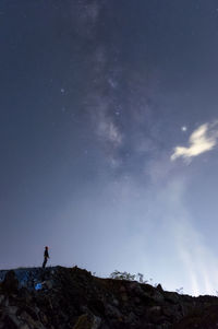 Silhouette man standing on mountain against sky at night