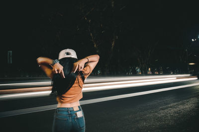 Full length of woman standing on road at night