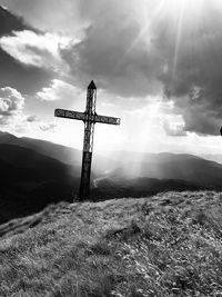 Cross on mountain against sky