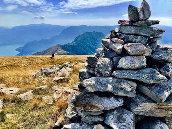Stack of rocks on landscape against sky