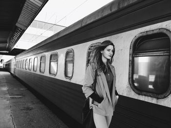 Portrait of woman walking by train at railroad station platform